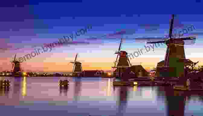 Iconic Windmills Of The Netherlands, Standing Tall Against The Backdrop Of A Vibrant Sunset Sky THE NETHERLANDS ROMANCE OF HISTORY